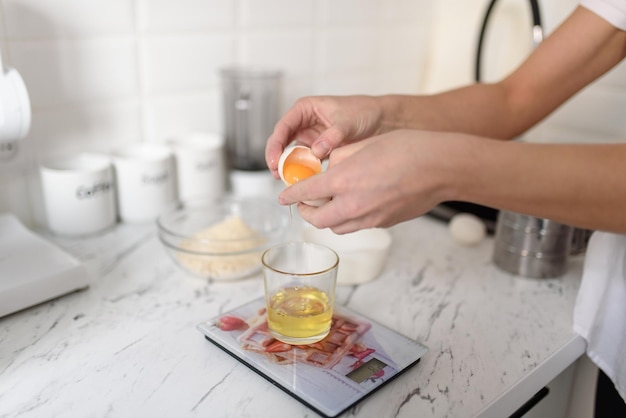 A woman separates egg yolks and whites for culinary and baking purposes