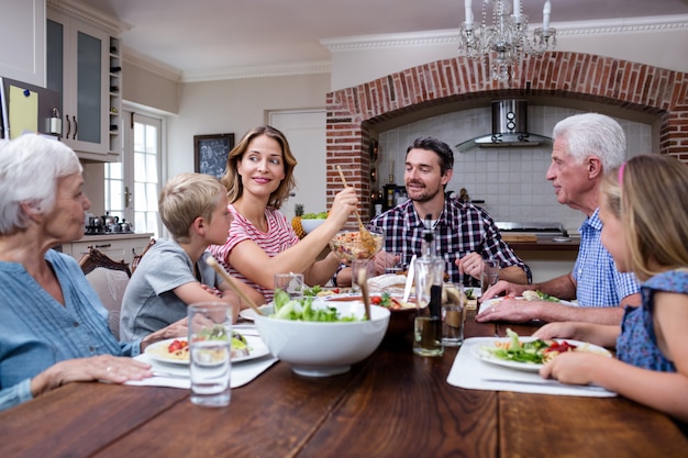 Woman serving food to her family in the kitchen