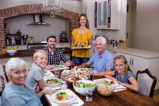 Woman serving food to her family in the kitchen