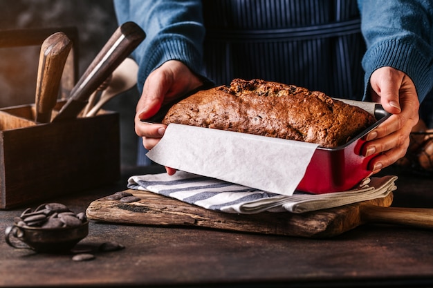 Woman serving grain loaf of bread