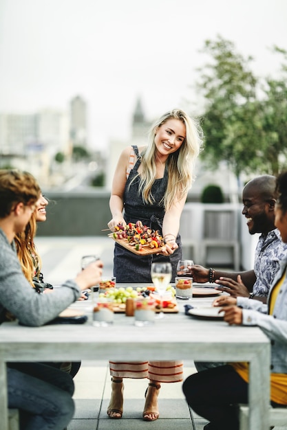 Woman serving vegan barbecue to her friends