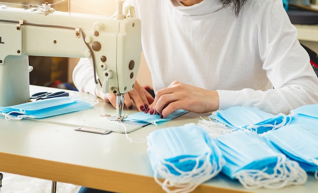 Woman sew the facial medical at sewing machine.