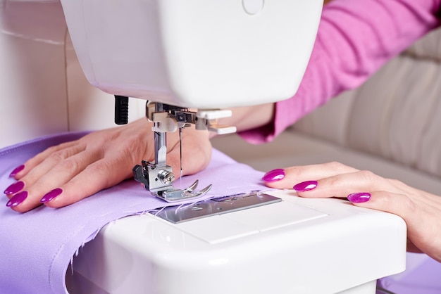 Woman sewing a dress on a sewing machine