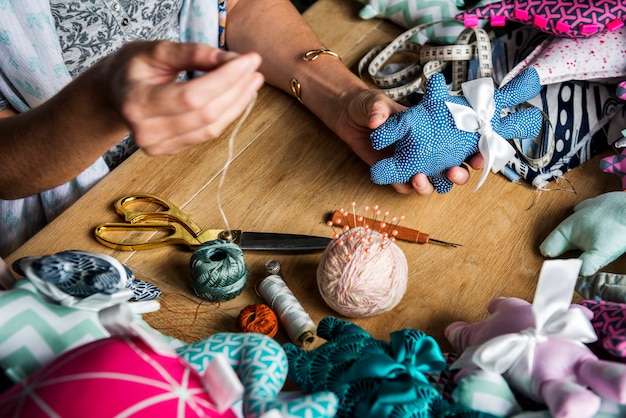 Woman sewing handmade doll on the table