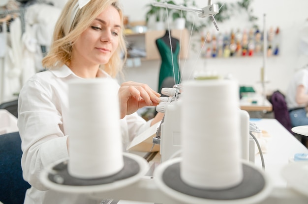 woman sews clothes on a sewing machine a tailor works at sewing in atelier textile industry hobby