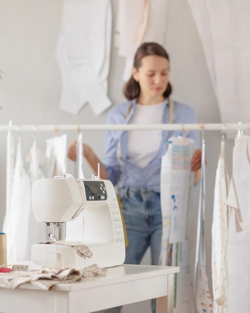 女性は、衣類や織物の生産のワークショップ作業でミシンで衣服を縫います