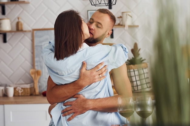 Woman in sexy black lingerie with her husband on the kitchen.