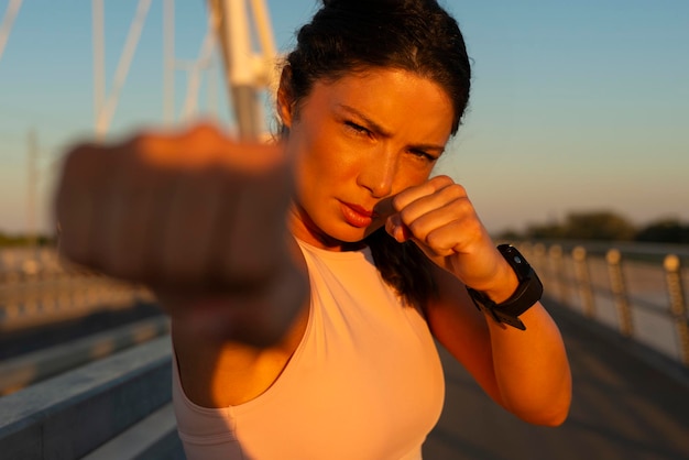 Foto donna che fa ombra di boxe con le mani avvolte sul ponte