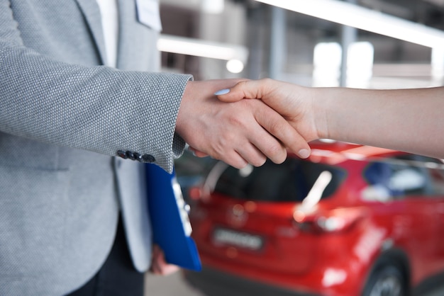 woman shaking hands with salesman in the showroom