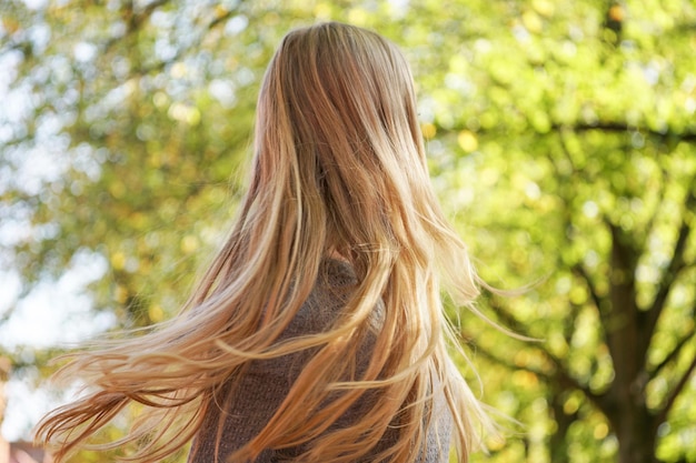 Женщина, качающая длинные светлые волосы.