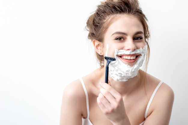 Woman shaving her face by razor