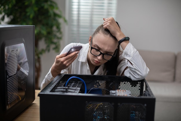 Foto donna che fa brillare la torcia all'interno di un computer rotto