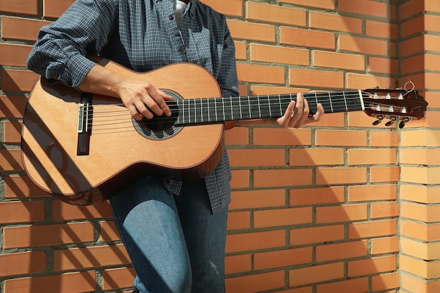 Woman in shirt playing on classical guitar