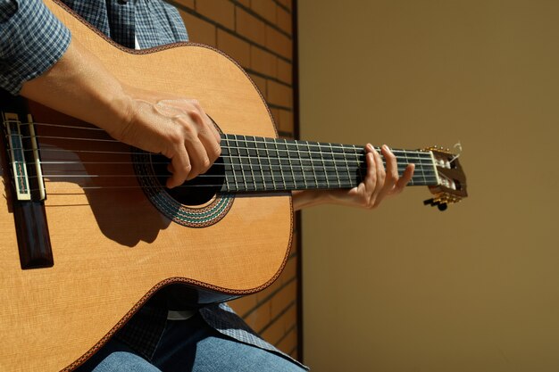 Woman in shirt playing on classical guitar