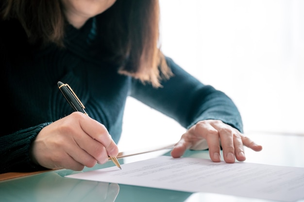 Woman in shirt signing document