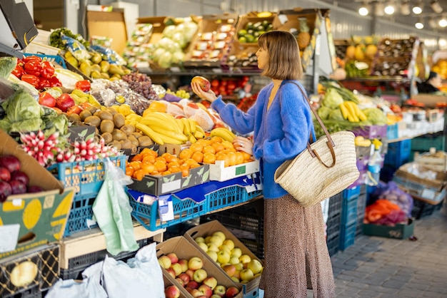 市場で食べ物を買い物する女性