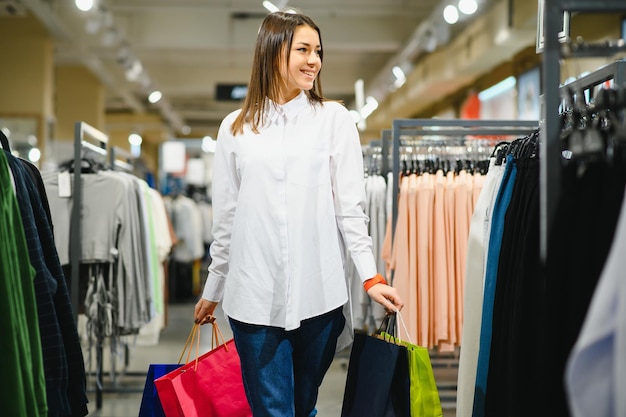 ショッピングの女性。ショッピングで楽しんで買い物袋を持つ幸せな女性。消費主義、ショッピング、ライフスタイルの概念