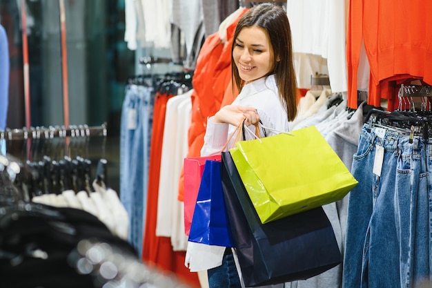 ショッピングの女性。ショッピングで楽しんで買い物袋を持つ幸せな女性。消費主義、ショッピング、ライフスタイルの概念