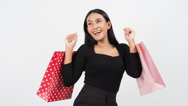 Woman shopping holding red shopping bags isolated.