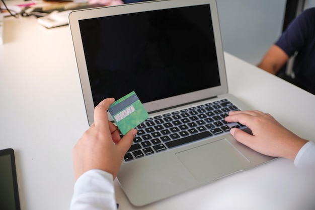 인터넷 온라인 전자 상거래 쇼핑 지출 돈 온라인 쇼핑 휴대 전화 노트북 개념에 대 한 신용 카드를 들고 노트북에 쇼핑 하는 여자