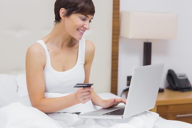 Woman shopping online in bed