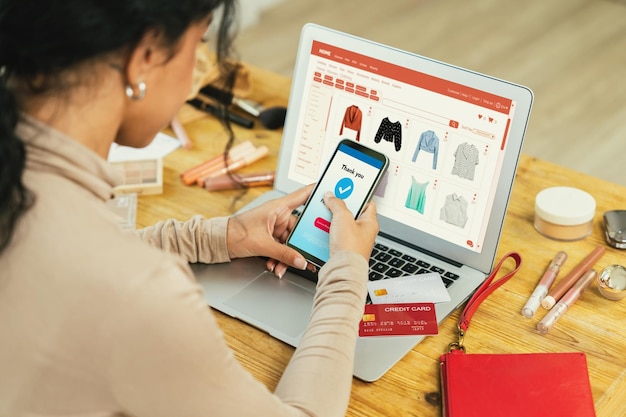 Женщина совершает покупки онлайн на интернет-рынке, просматривает товары для современного образа жизни и использует кредитную карту для онлайн-платежей из кошелька, защищенного важным программным обеспечением кибербезопасности.