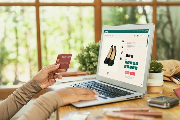 Woman shopping online on internet marketplace browsing for sale items for modern lifestyle and use credit card for online payment from wallet protected by crucial cyber security software