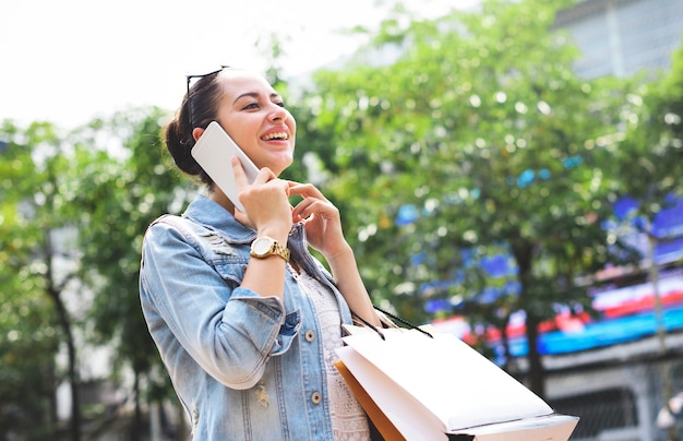 Photo woman shopping outdoor talking mobile phone concept