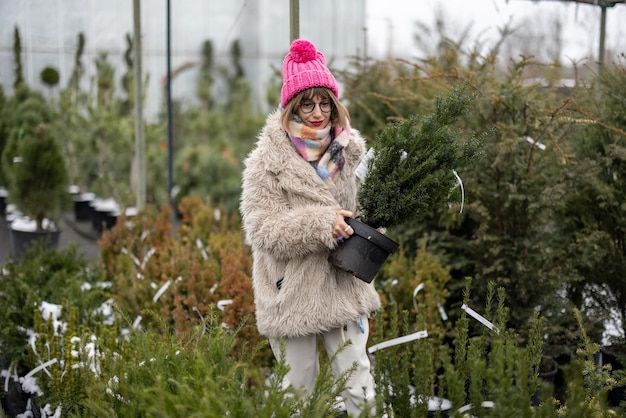 Woman shopping plants at open air market during winter time