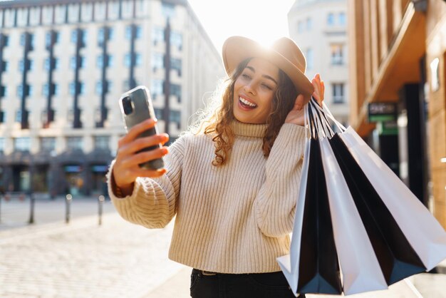 Foto donna nello shopping ragazza giovane con borse della spesa colorate che passeggia per la città dopo lo shopping