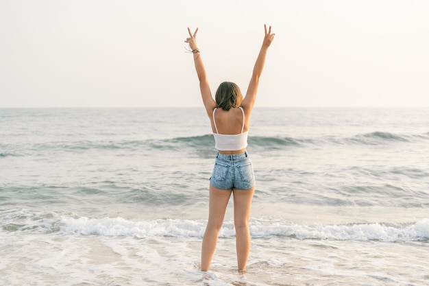 Woman on the shore of the beach from behind