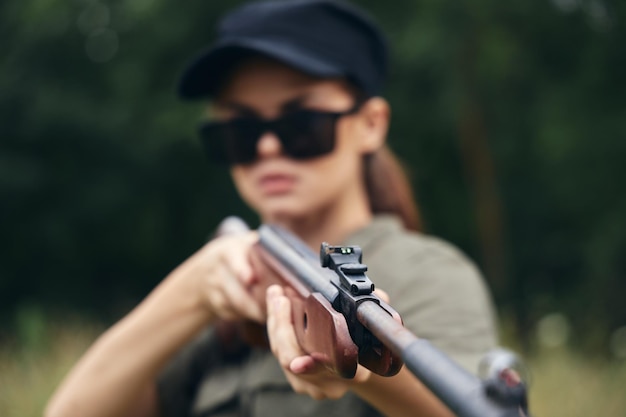 Photo woman shotgun in hand sight target hunting green leaves