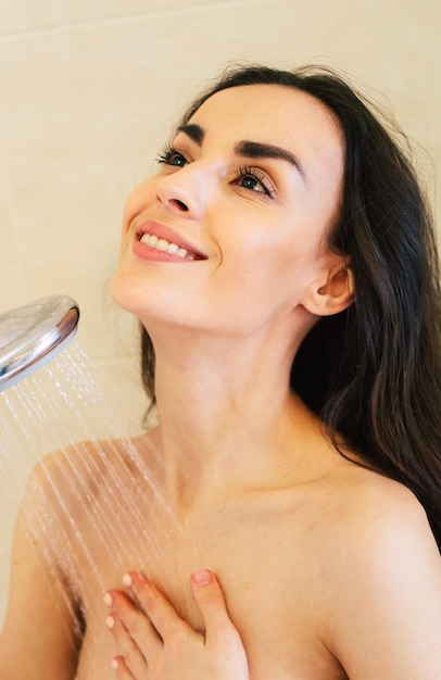 Woman in the shower Beautiful smiling girl getting ready to take a shower