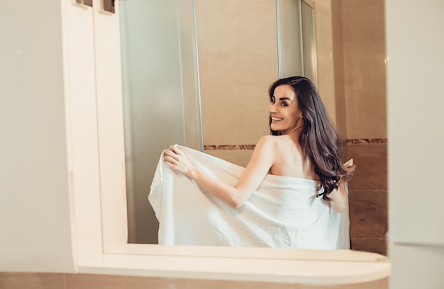 Woman in the shower Beautiful smiling girl getting ready to take a shower