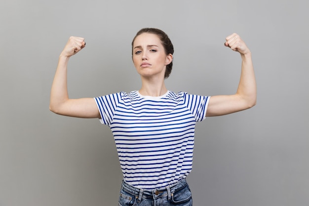 Woman showing biceps expressing power ambitions to become successful female rights feminism