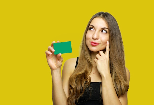 Woman showing credit card and looking away isolated