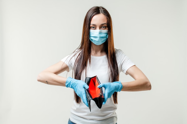 Woman showing empty wallet wearing mask and gloves