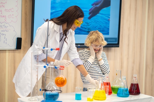 Woman showing flasks with liquid to boy