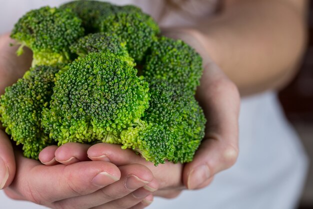 Woman showing fresh green brocolli