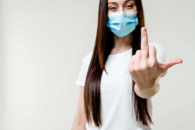 Woman showing fuck you middle finger wearing mask