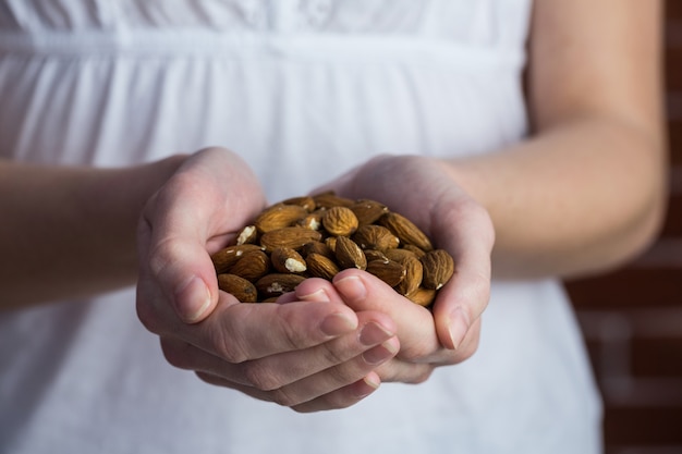 Woman showing handful of almonds