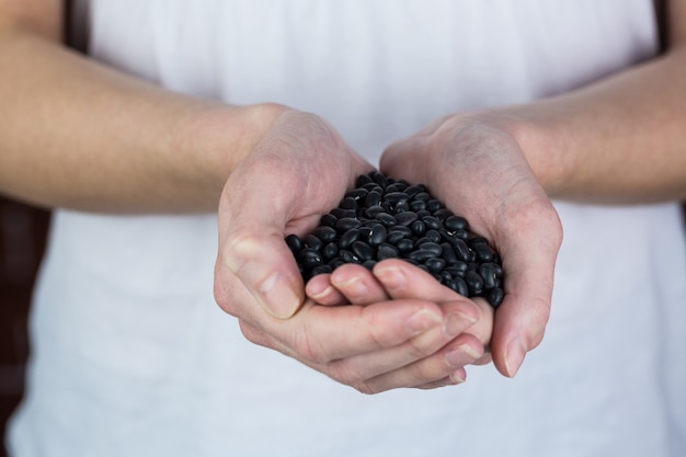 Woman showing handful of black beans