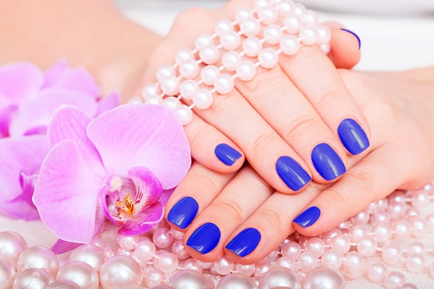 Woman showing her beautiful nails with manicure and flowers