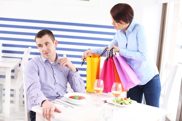 a woman showing her new purchase to husband in a restaurant