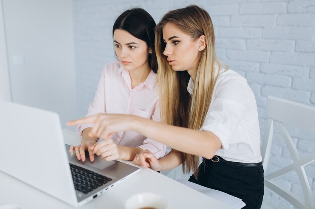 Woman showing laptop to colleague