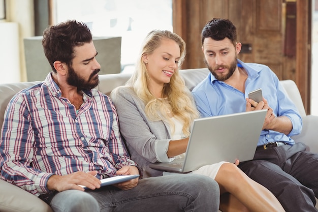 Woman showing laptop to colleagues 