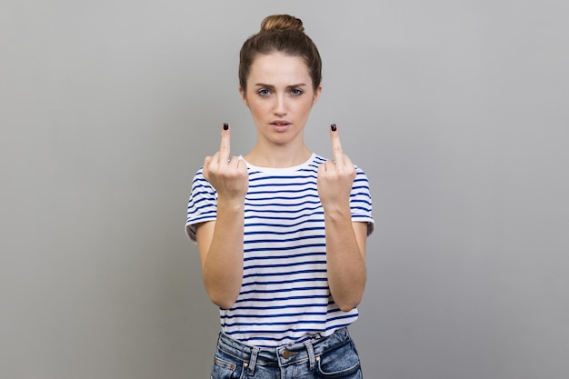 Woman showing middle finger rude gesture face full of hatred and resentment