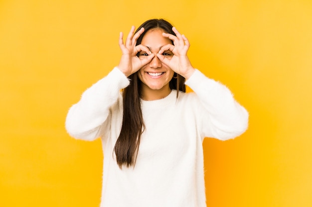 Woman showing okay sign over eyes