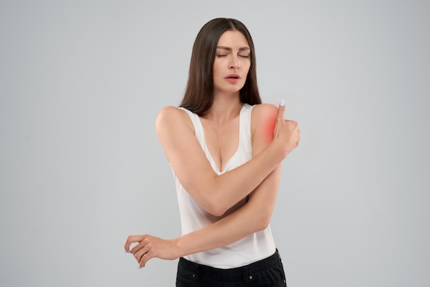 Woman showing pain in shoulder