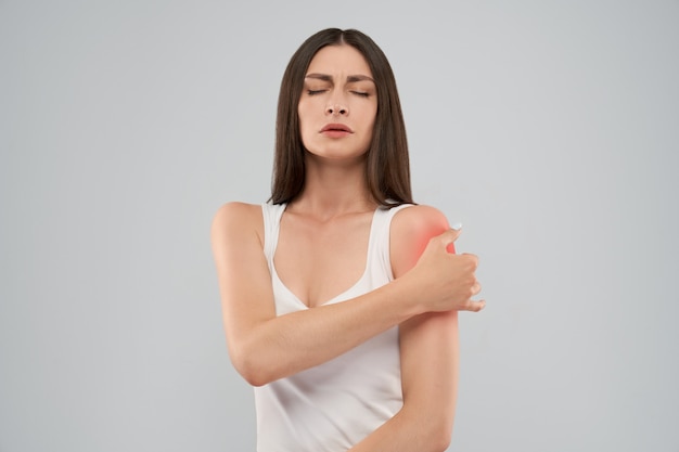 Woman showing pain in shoulder